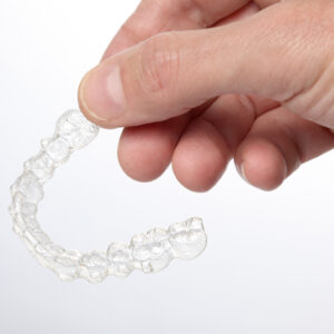 Man’s,Hand,Hold,A,Teeth,Brace,Aligner,Isolated,On,White